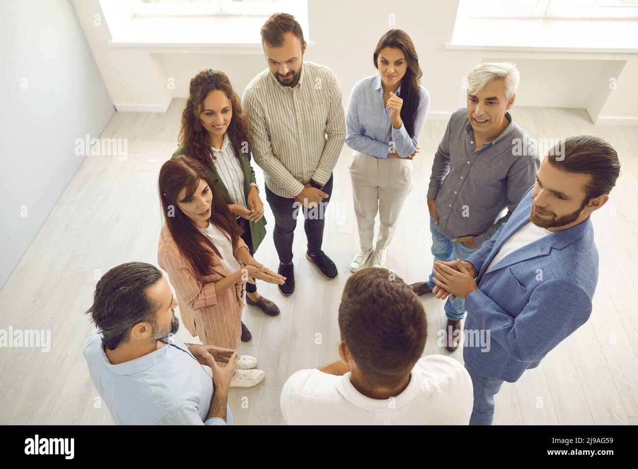 Group of people listening to business coach while standing in office during workshop Stock Photo