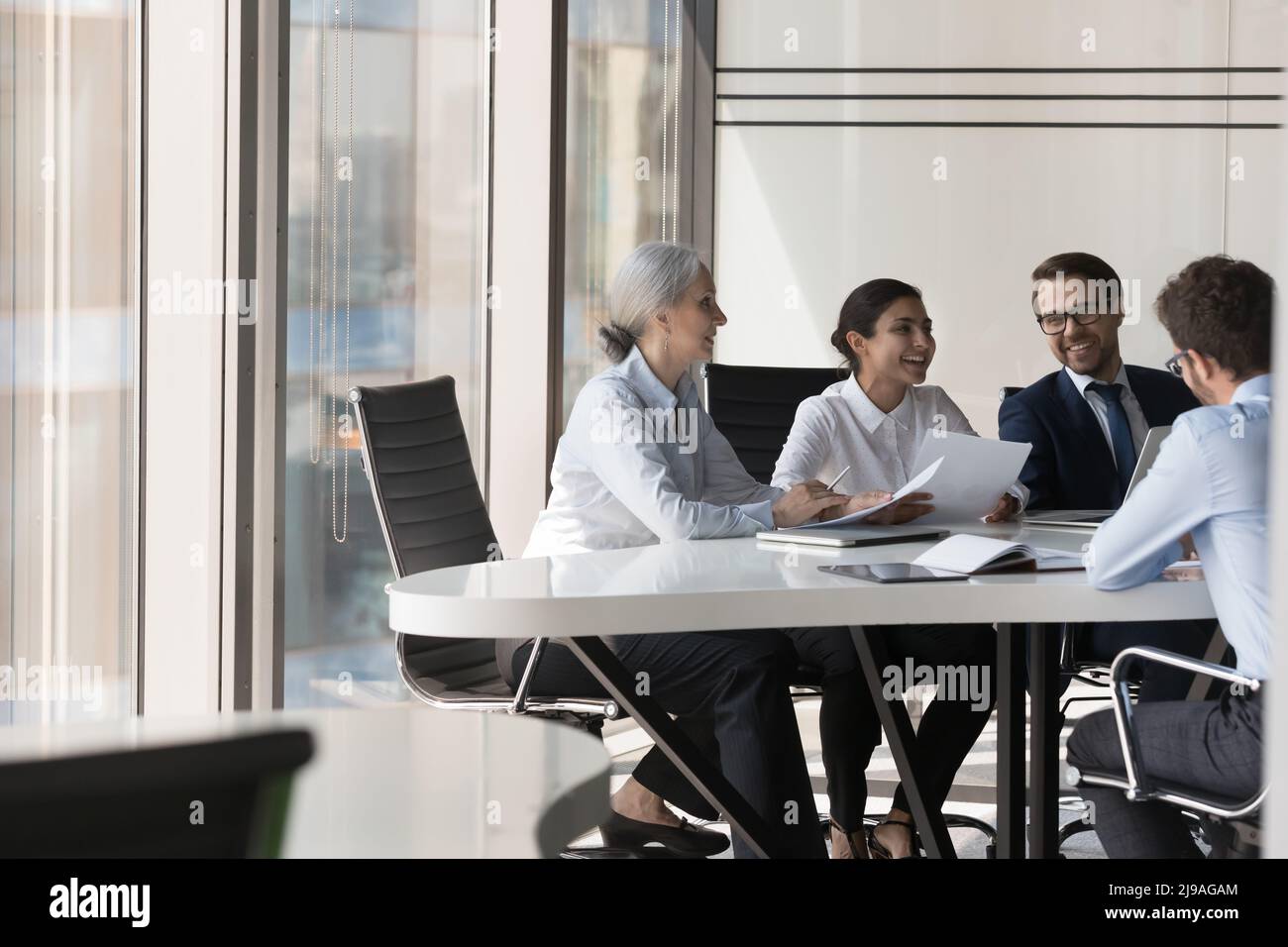 Diverse businesspeople develop business strategy during meeting in boardroom Stock Photo