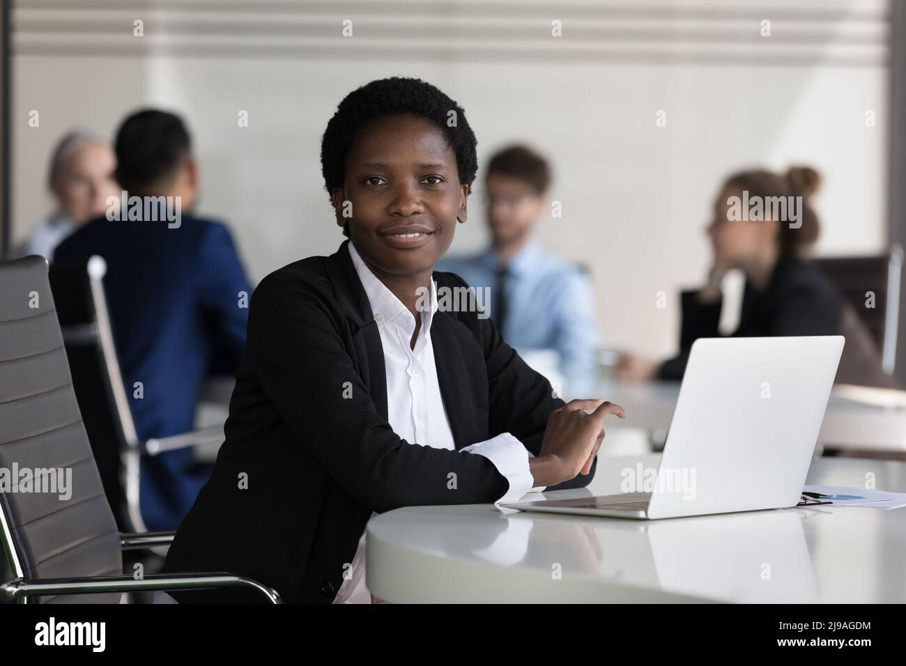 Successful African businesswoman posing sit at desk in office Stock ...