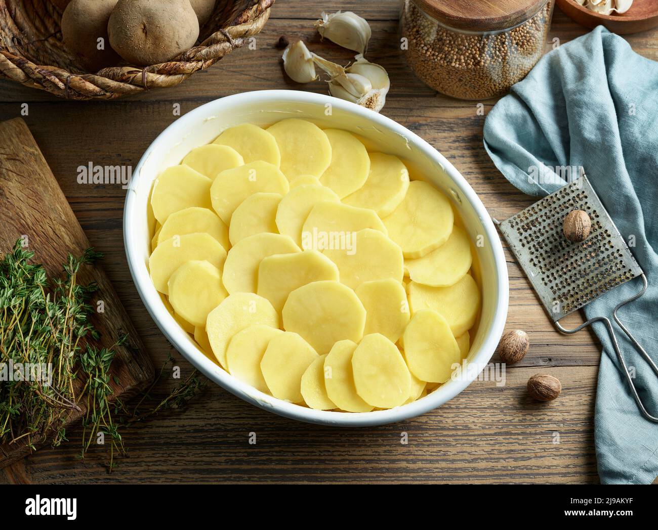 bowl of fresh raw potato slices, process of making potato gratin Stock