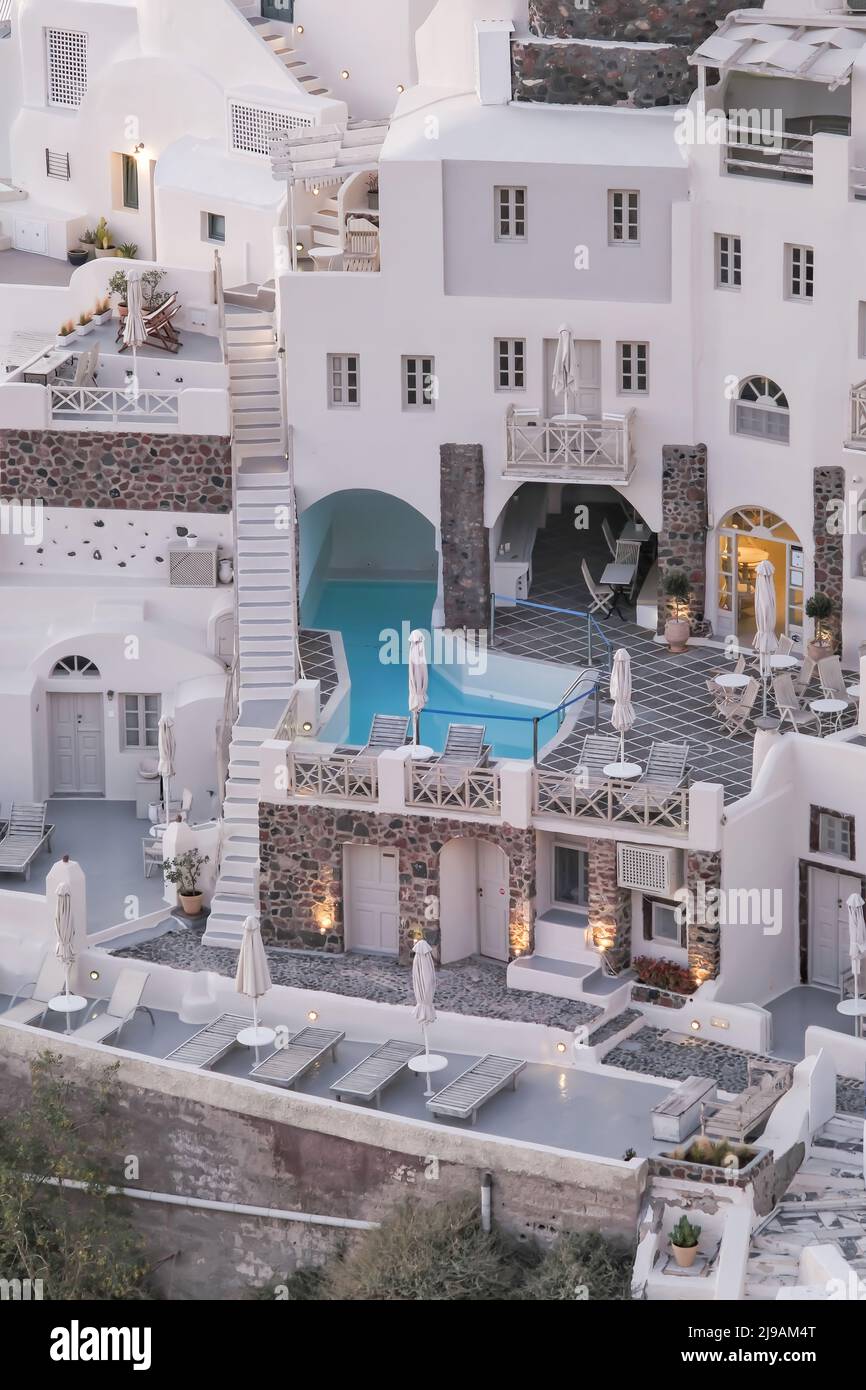 Oia, Greece - May 11, 2021 : Panoramic view of a stunning whitewashed hotel with swimming pools in Oia Santorini Stock Photo