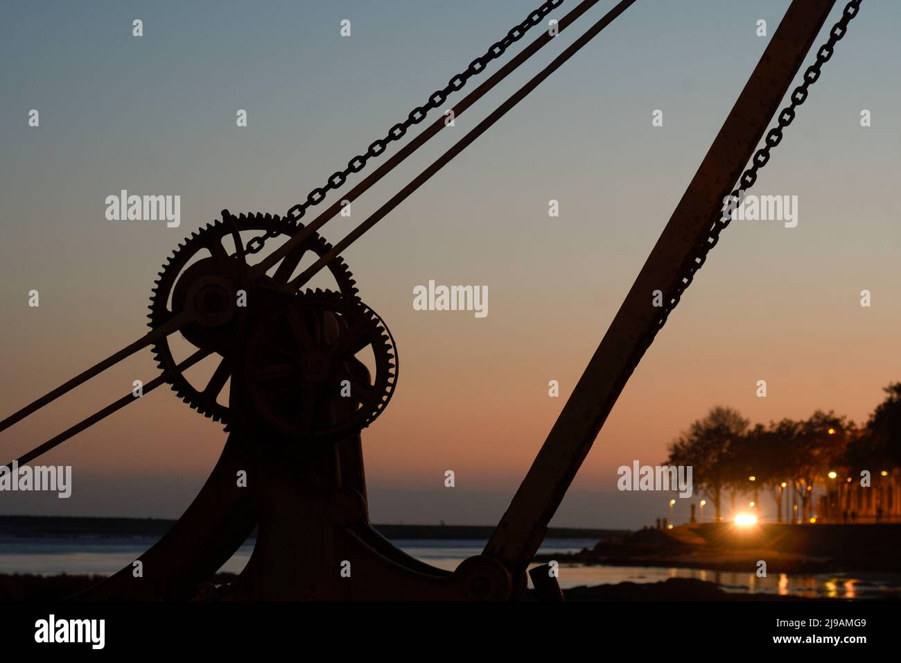 Silhouette of an old crane at dusk in Porto Stock Photo