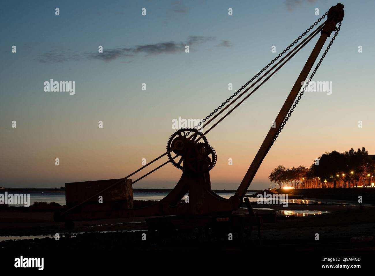 Silhouette of an old crane at dusk in Porto Stock Photo