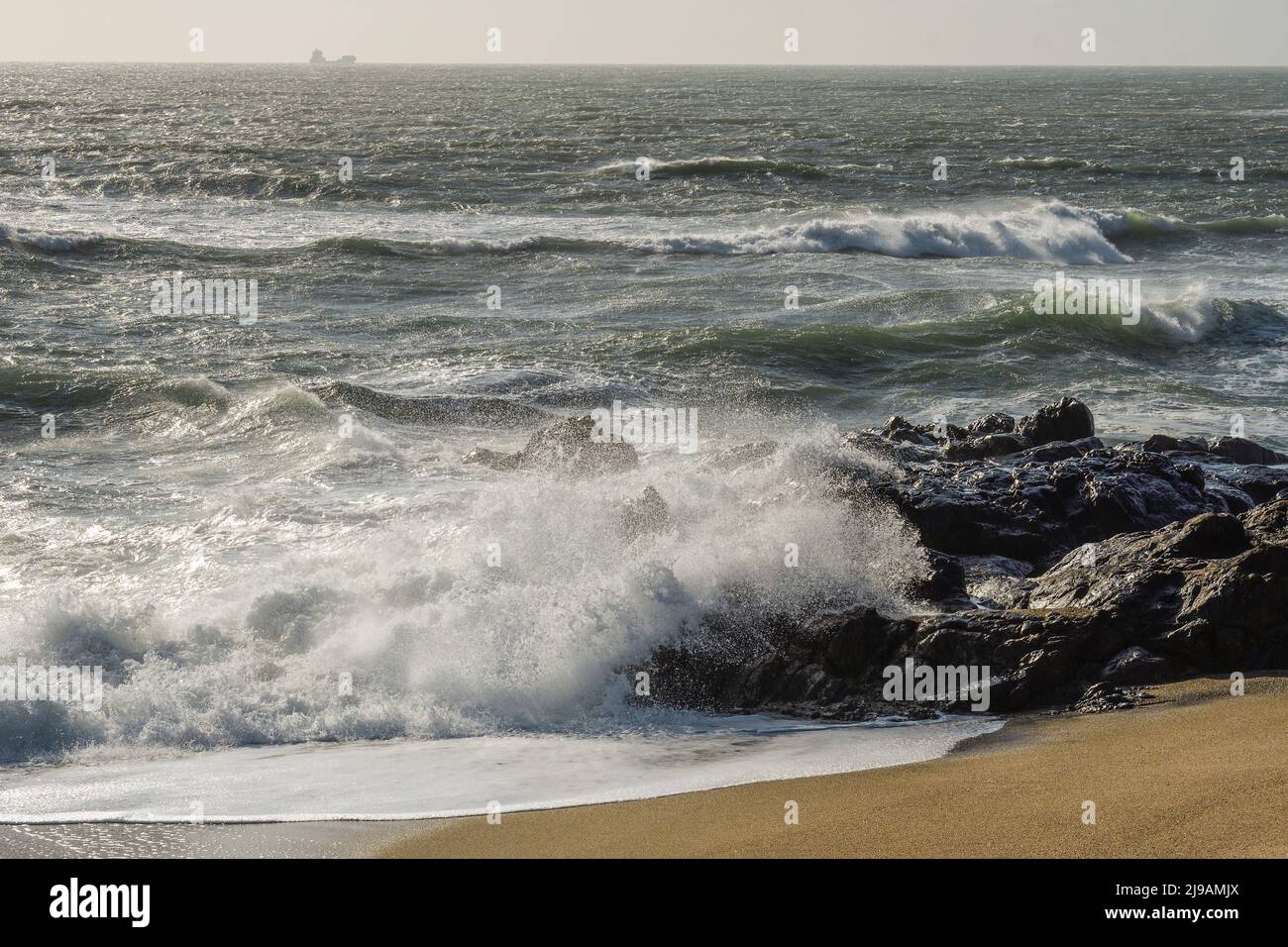 Waves breaking on the rocks of the beach Stock Photo