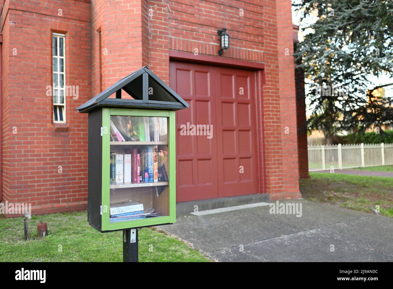 Little free library structure filled with books street side, outside St Andrew's Presbyterian Church, accessible to the local community Stock Photo