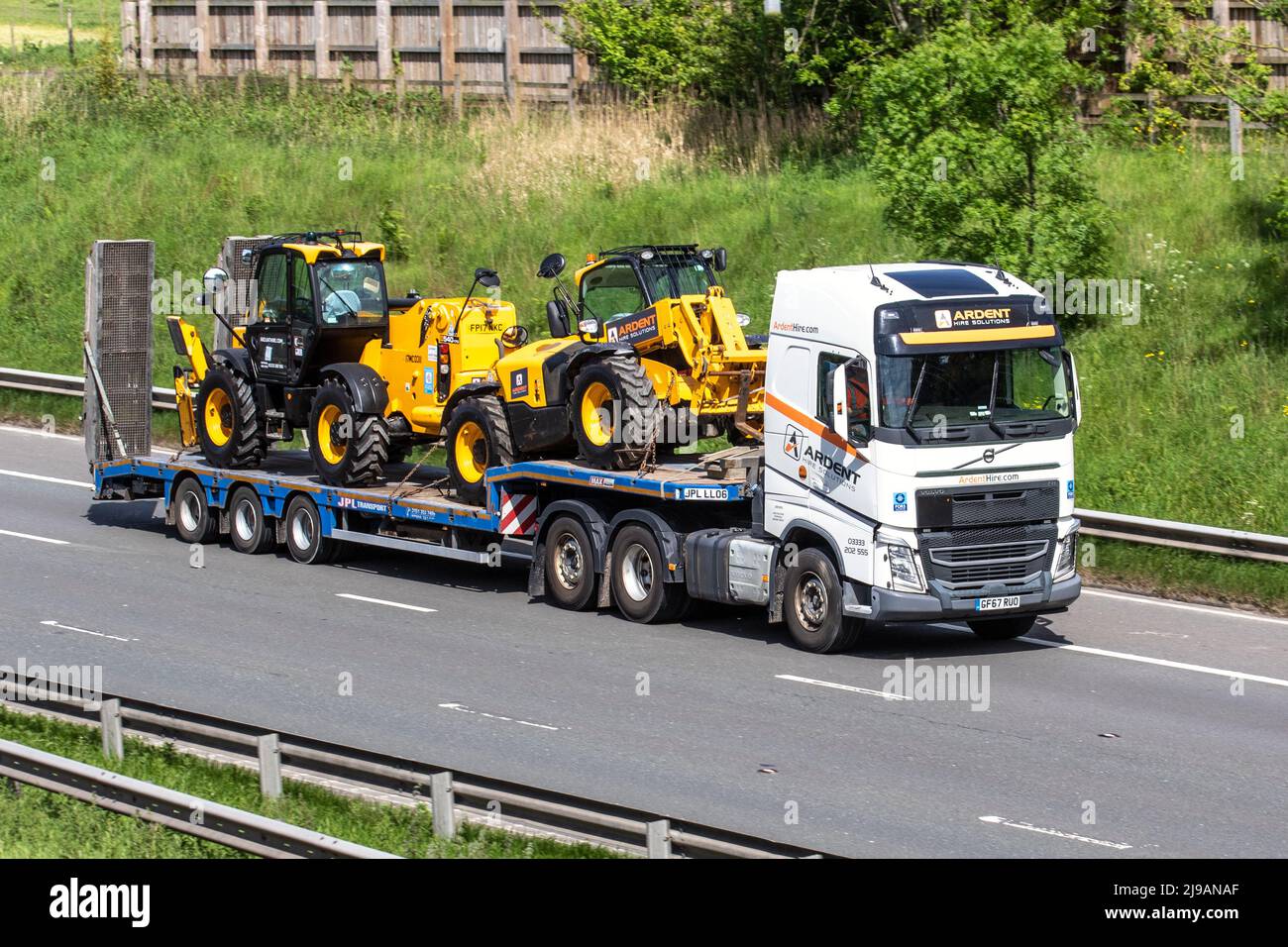 ARDENT HIRE SOLUTIONS 2017 white VOLVO FH500 6X2T PA HSKLP towing Max Trailer with two yellow JCB 4400 cc 540-17 tractors telescopic handlers on low-loader; driving on the M6 Motorway, Manchester, UK Stock Photo