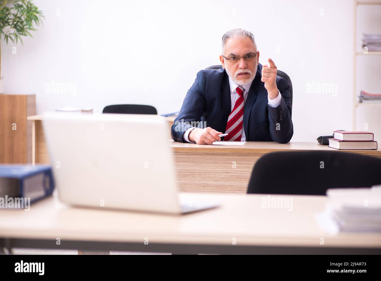 Old male employee working at workplace Stock Photo - Alamy