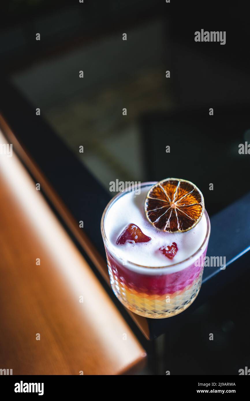 fresh stylish layered pink sour grapefruit cocktail with foam and ice Stock Photo