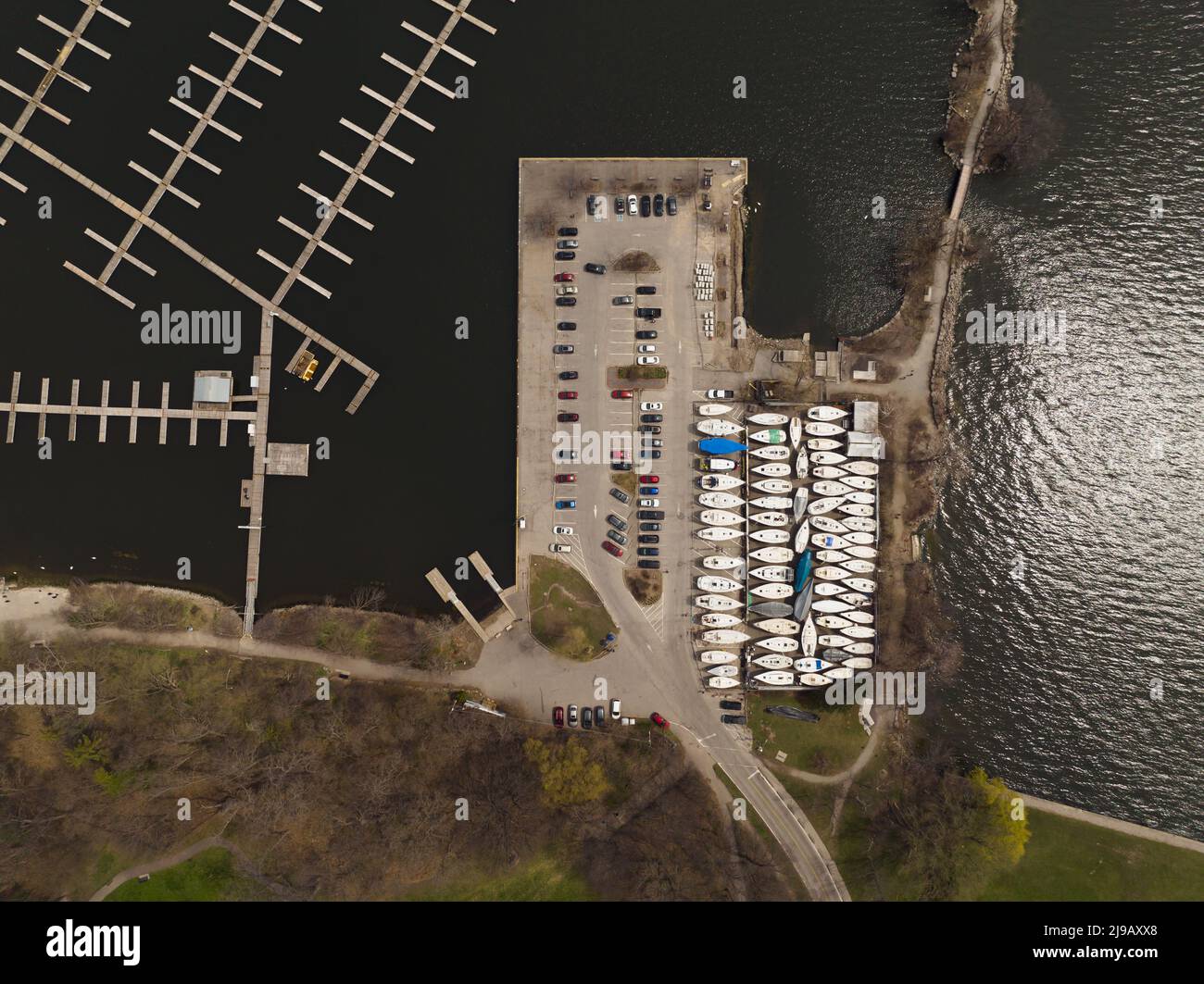 An aerial view above a large boat harbor, seen during the offseason with any empty water harbor and boats seen on land storage. Stock Photo