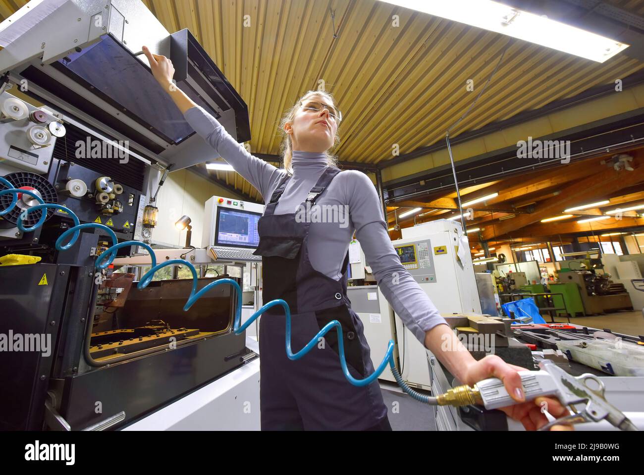A female trainee receives technical tuition from her instructor. Both women work as computerized  numerical control engineers. Stock Photo
