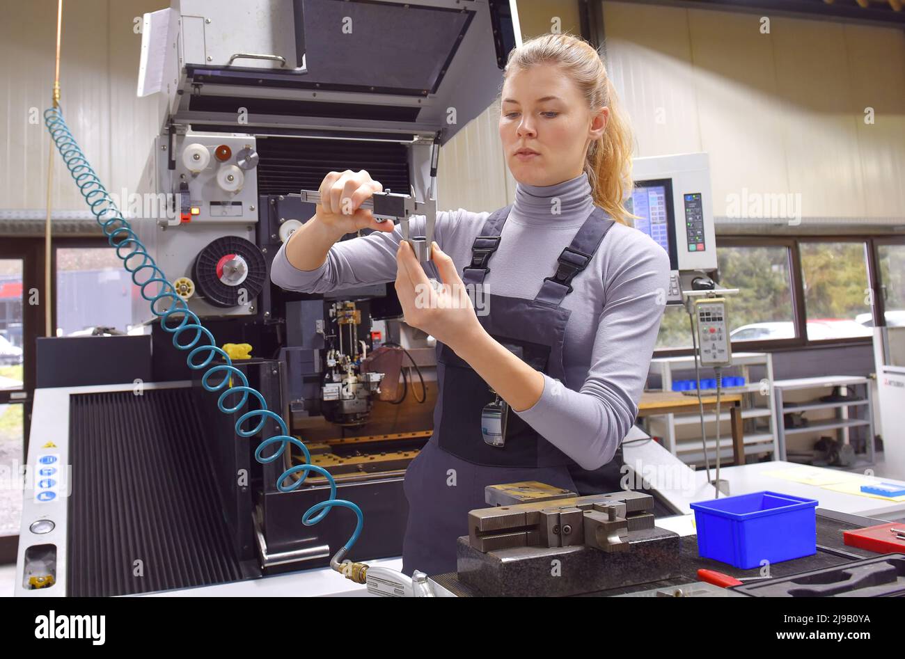 A female trainee receives technical tuition from her instructor. Both women work as computerized  numerical control engineers. Stock Photo