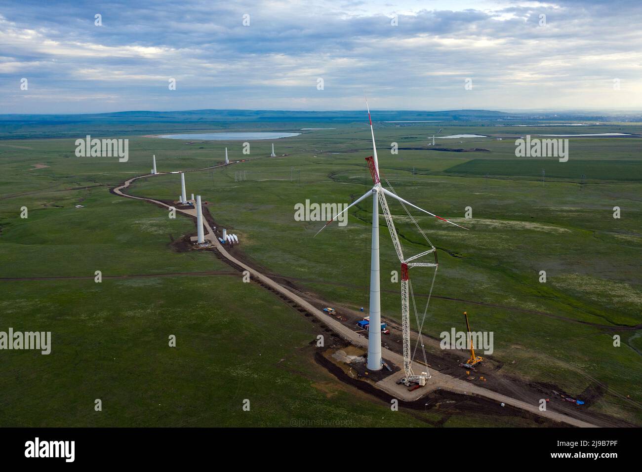 Wind turbine constraction at sunset. Installation the rotor blades on
