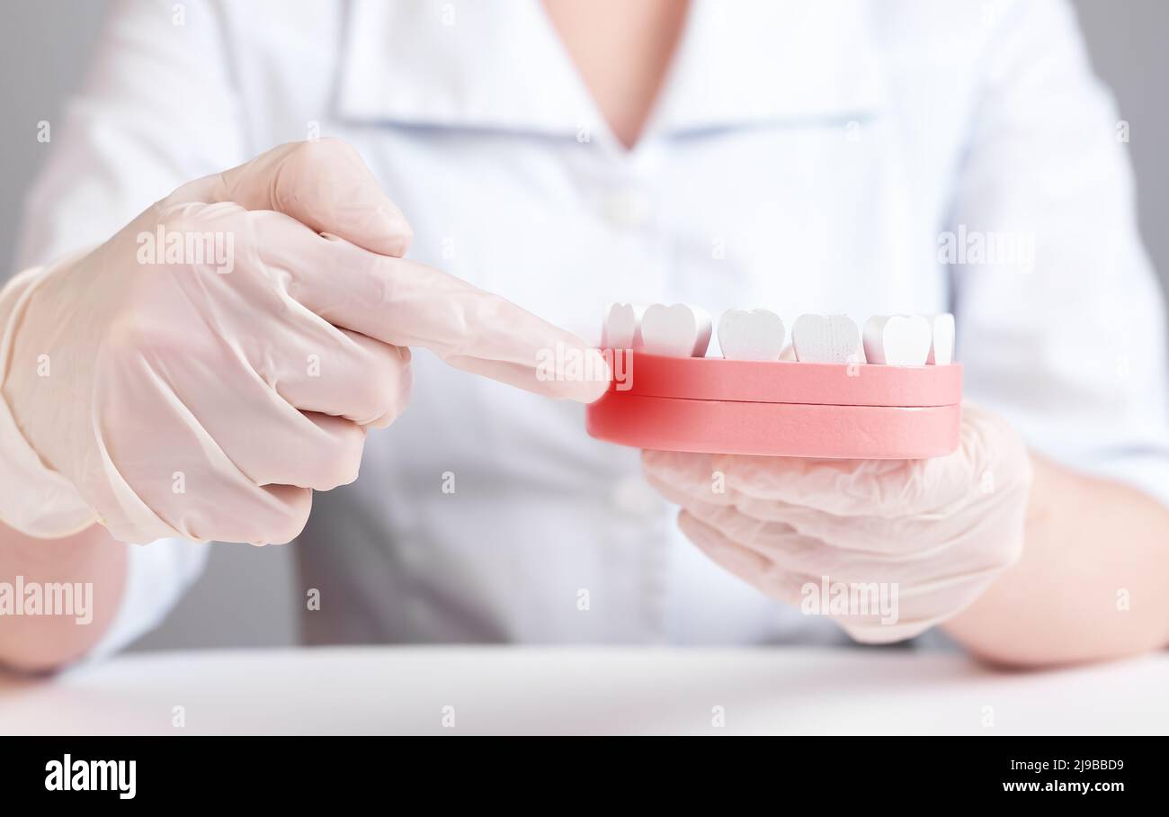 Gingiva inflammation. Dentist forefinger pointing to red point at jaw