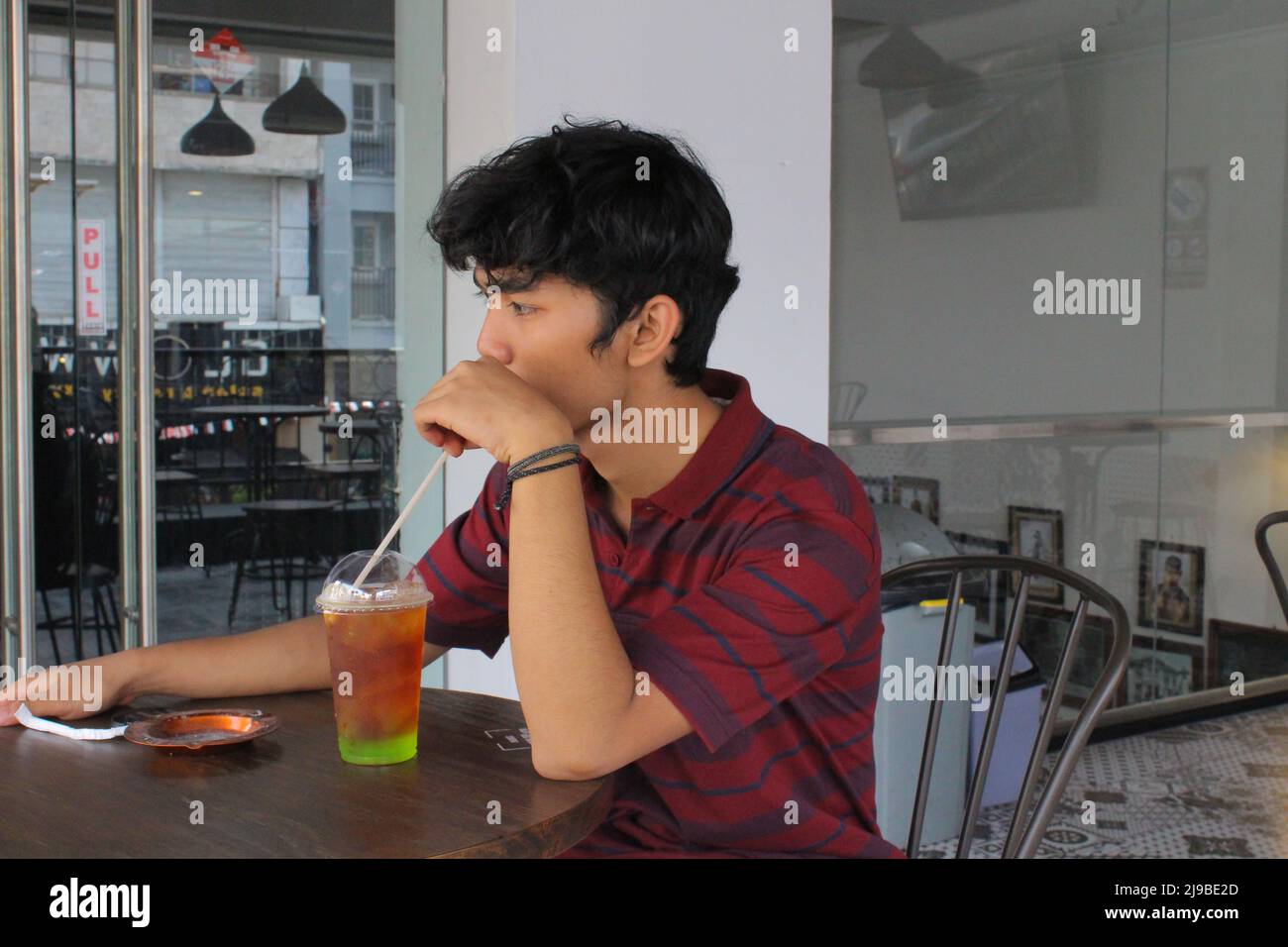 Yogyakarta, Indonesia - 08 07 2019: a man enjoying his drink while on vacation in a special area of Yogyakarta, Central Java Stock Photo