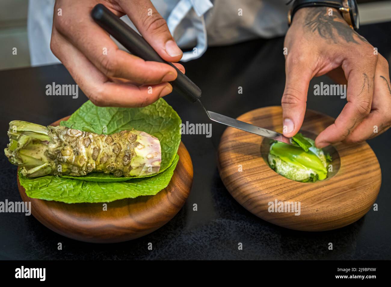 Chefs appreciate the many uses and balancing effects of fresh wasabi. Here, top chef Runar Pierre from the Öx restaurant in Reykjavik preparing a dessert. Stock Photo