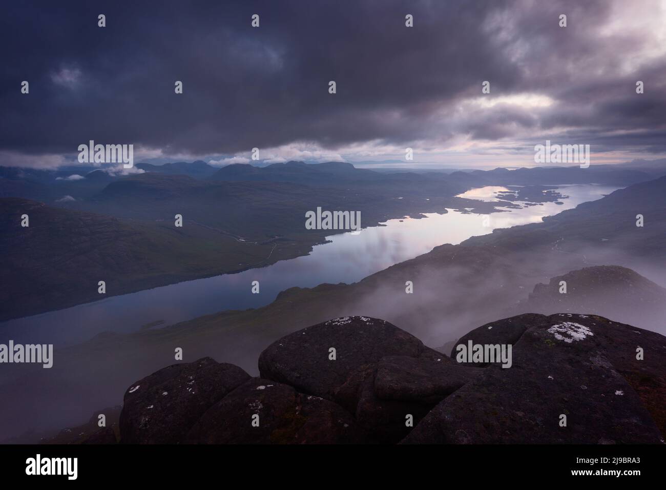 View over Loch Maree, Torridon, Scotland at dusk while clouds pass by just below the sumit of Slioch Stock Photo
