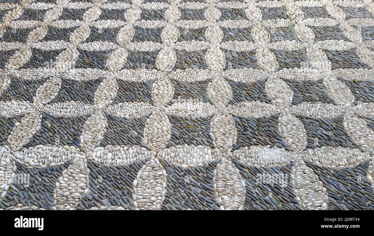 Cobbled pavement made of river rounded pebbles in Cordoba, Andalusia, Spain. Background texture. Patio Andaluz Stock Photo