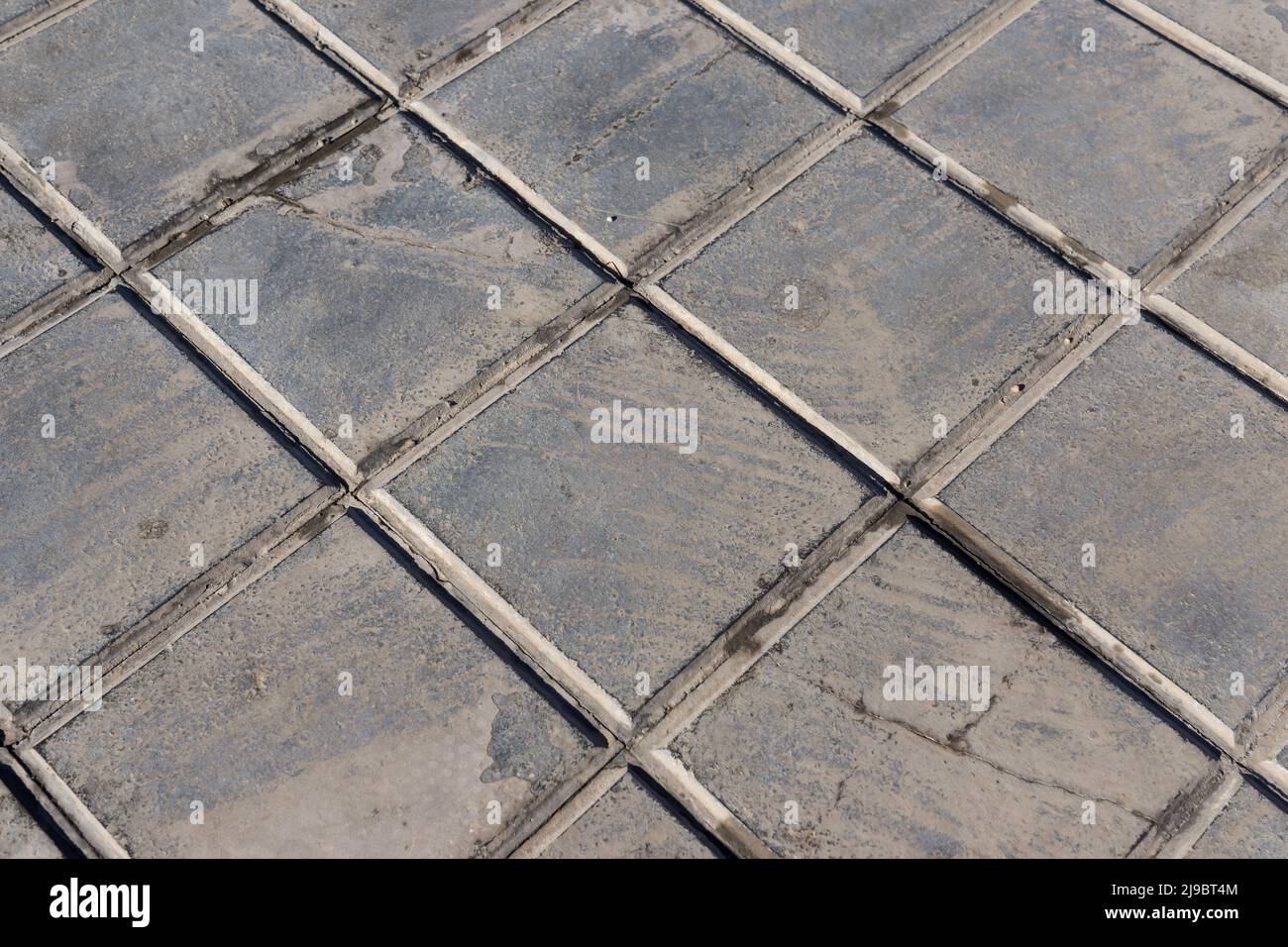 concrete tile for outdoor use Sidewalks, non-slip and wear resistance paving with tile Dirty and broken hydraulic tiles, pattern detail Stock Photo