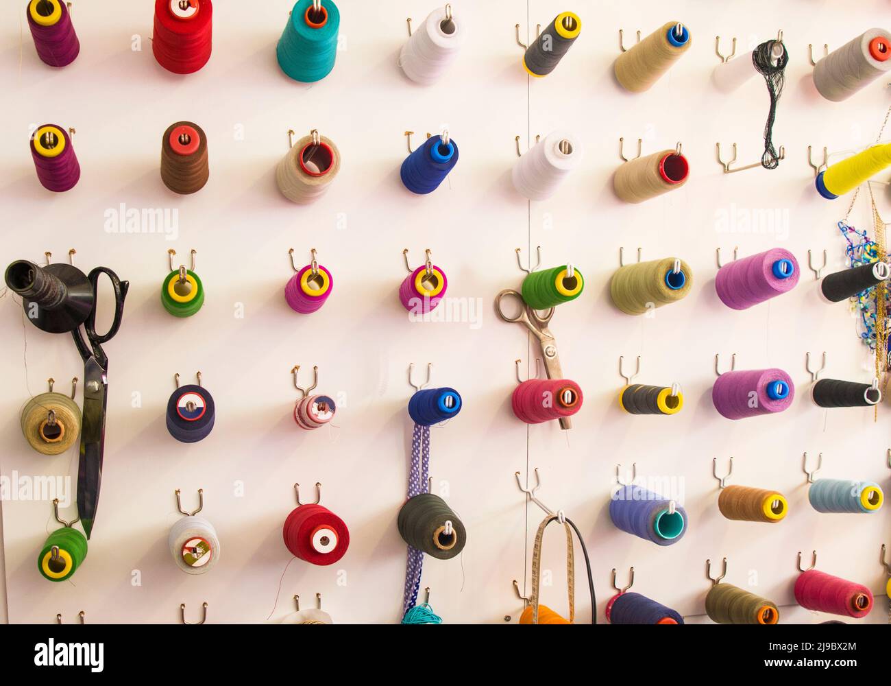 Multicolored coils and scissors on the wall Stock Photo