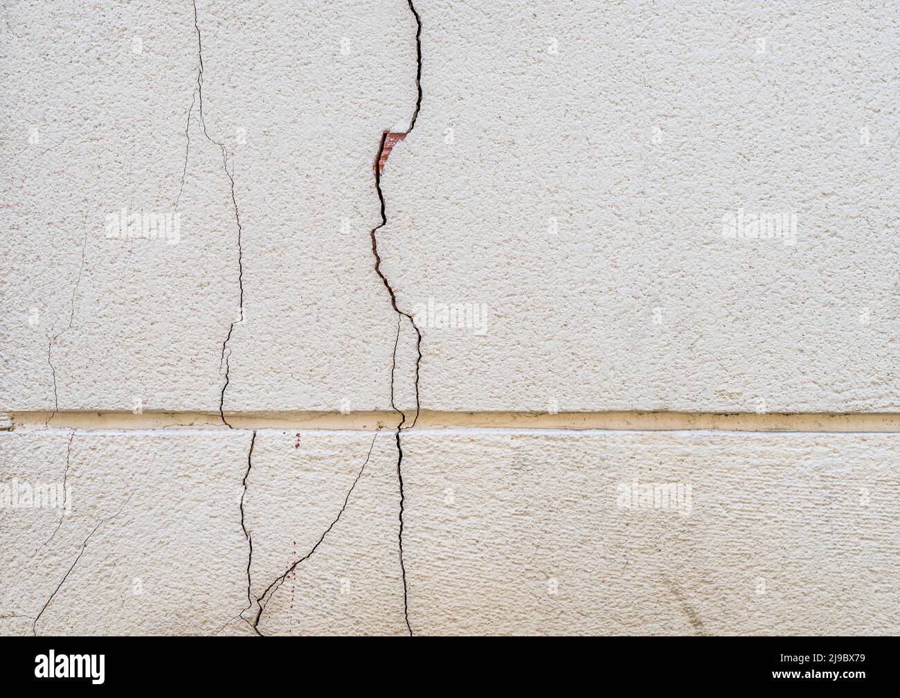 Damaged broken building facade, fissured surfaces of concrete Stock Photo