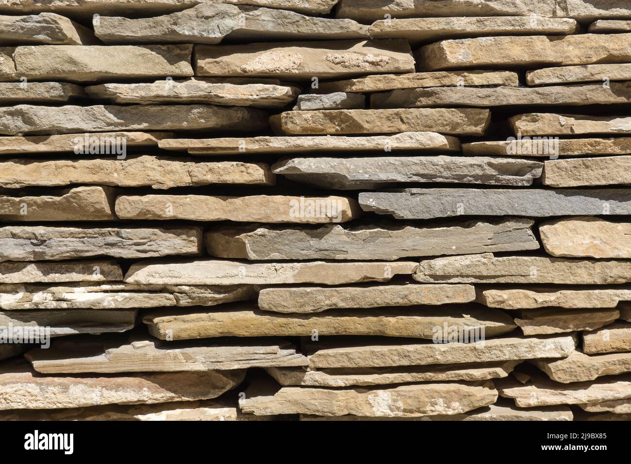 slate flagstone wall of large irregular pieces of stone ruins brown background detail Stock Photo