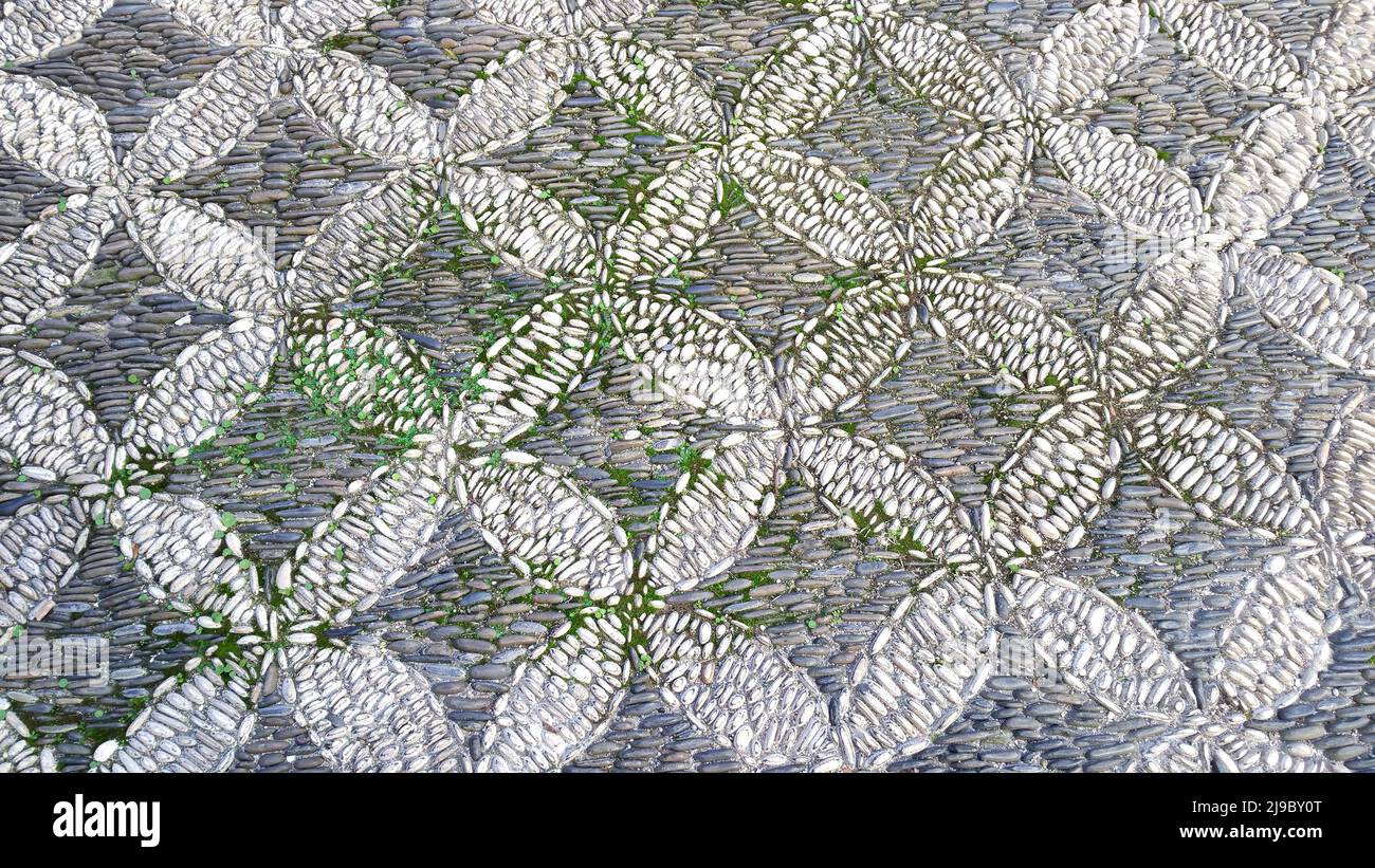 Cobbled pavement made of river rounded pebbles in Cordoba, Andalusia, Spain. Background texture. Patio Andaluz Stock Photo