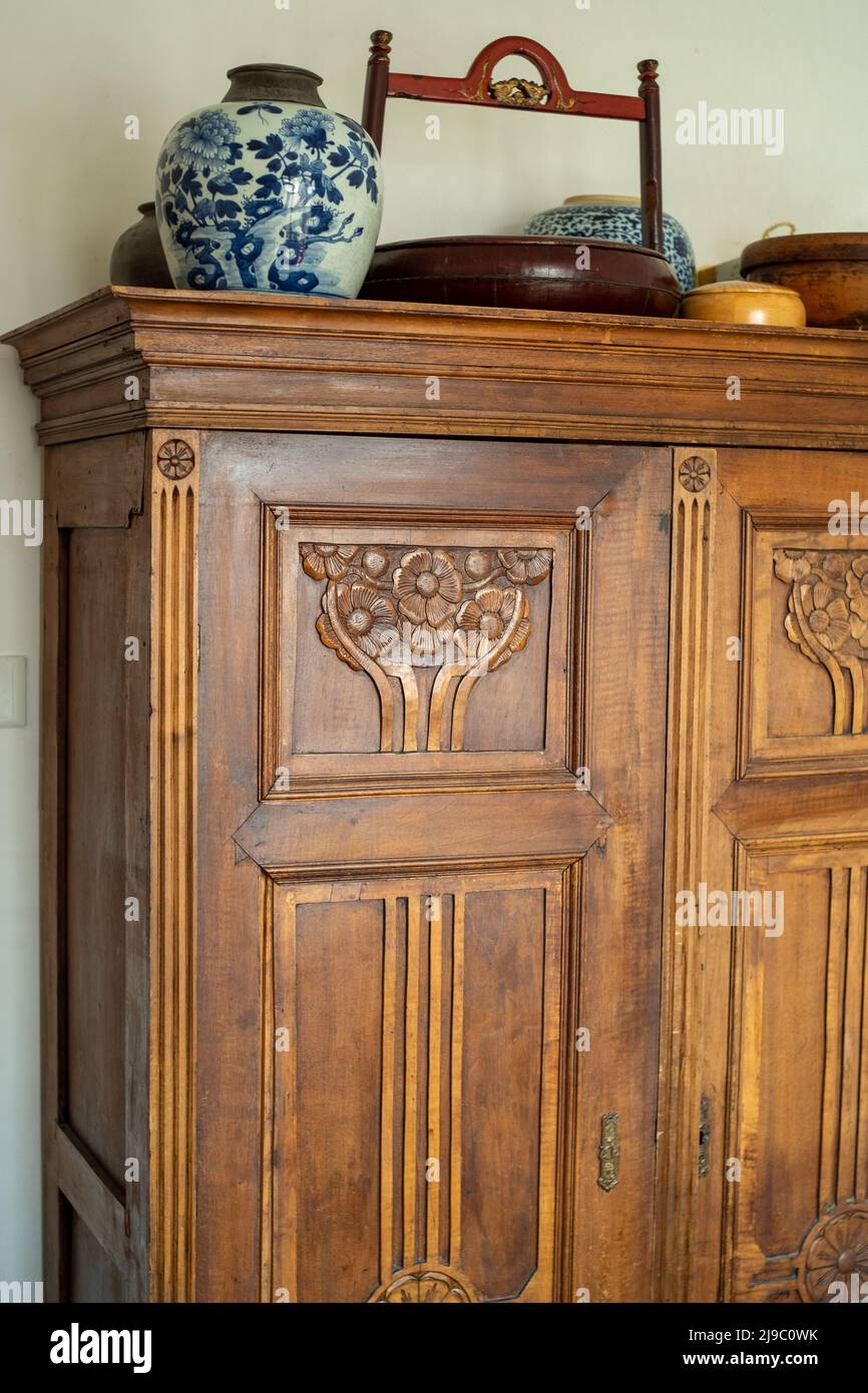 Hungarian antique oak wardrobe with Chinese antiques on top. Stock Photo
