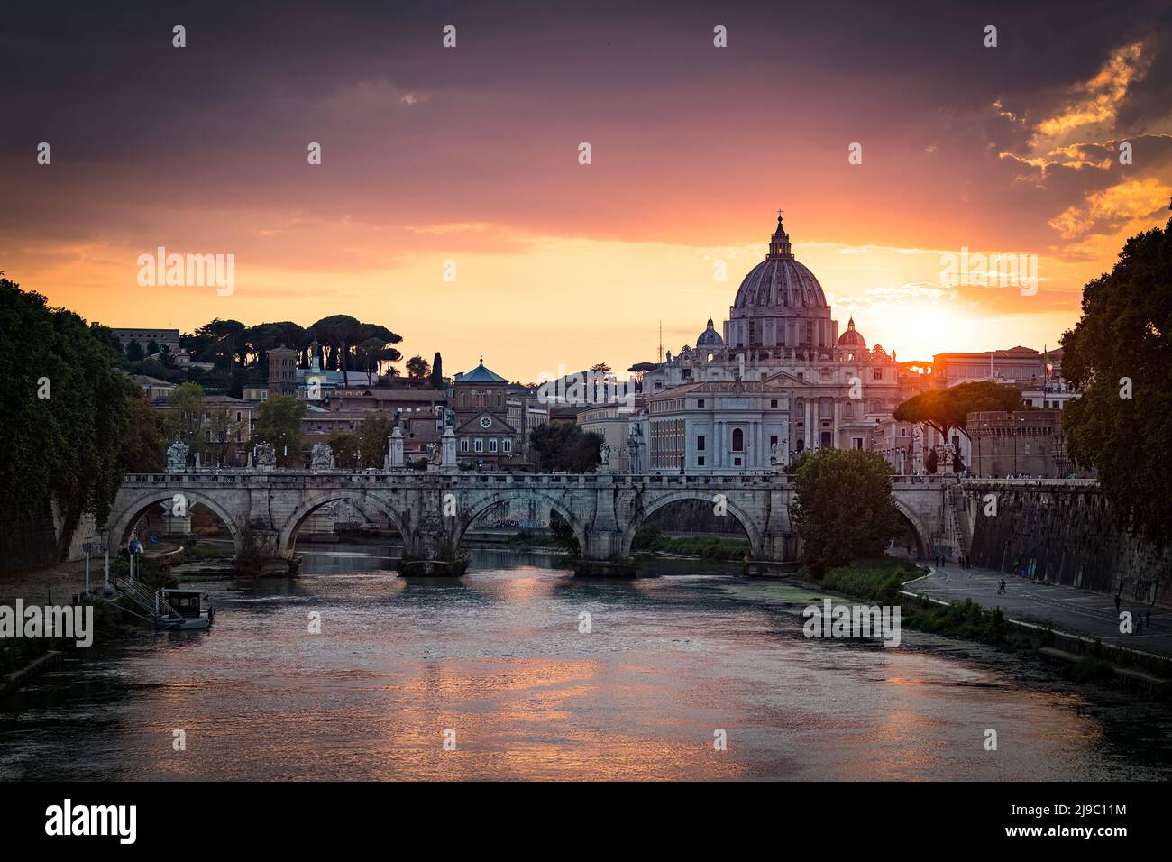 Sunset view of old Sant' Angelo Bridge and St. Peter's cathedral in Vatican City, Rome.Italy Stock Photo