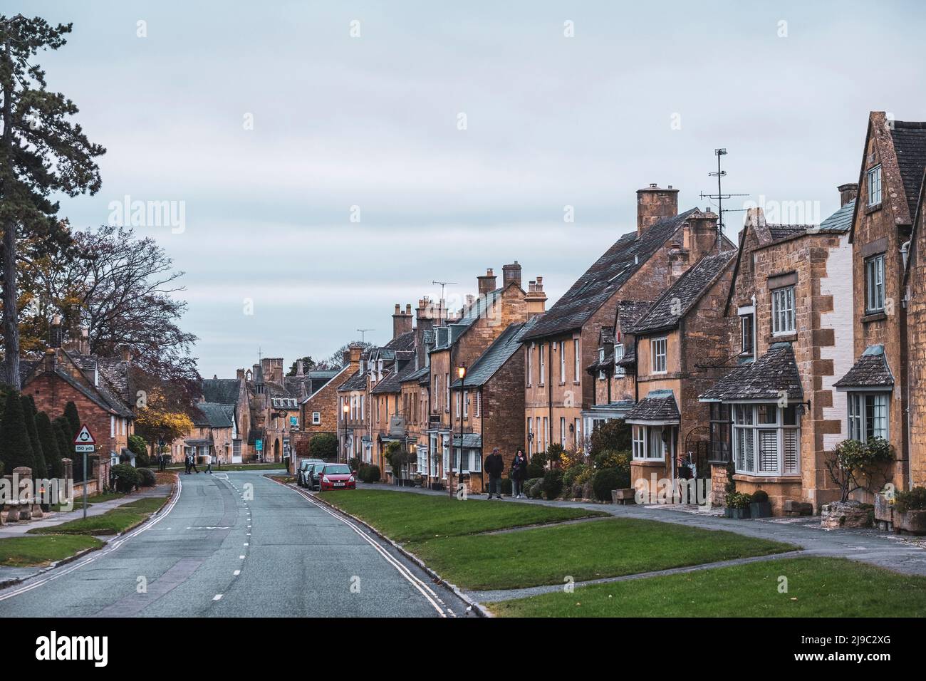 The yellow Cotswold stone of these pubs and houses makes this a picturesque scene. Stock Photo
