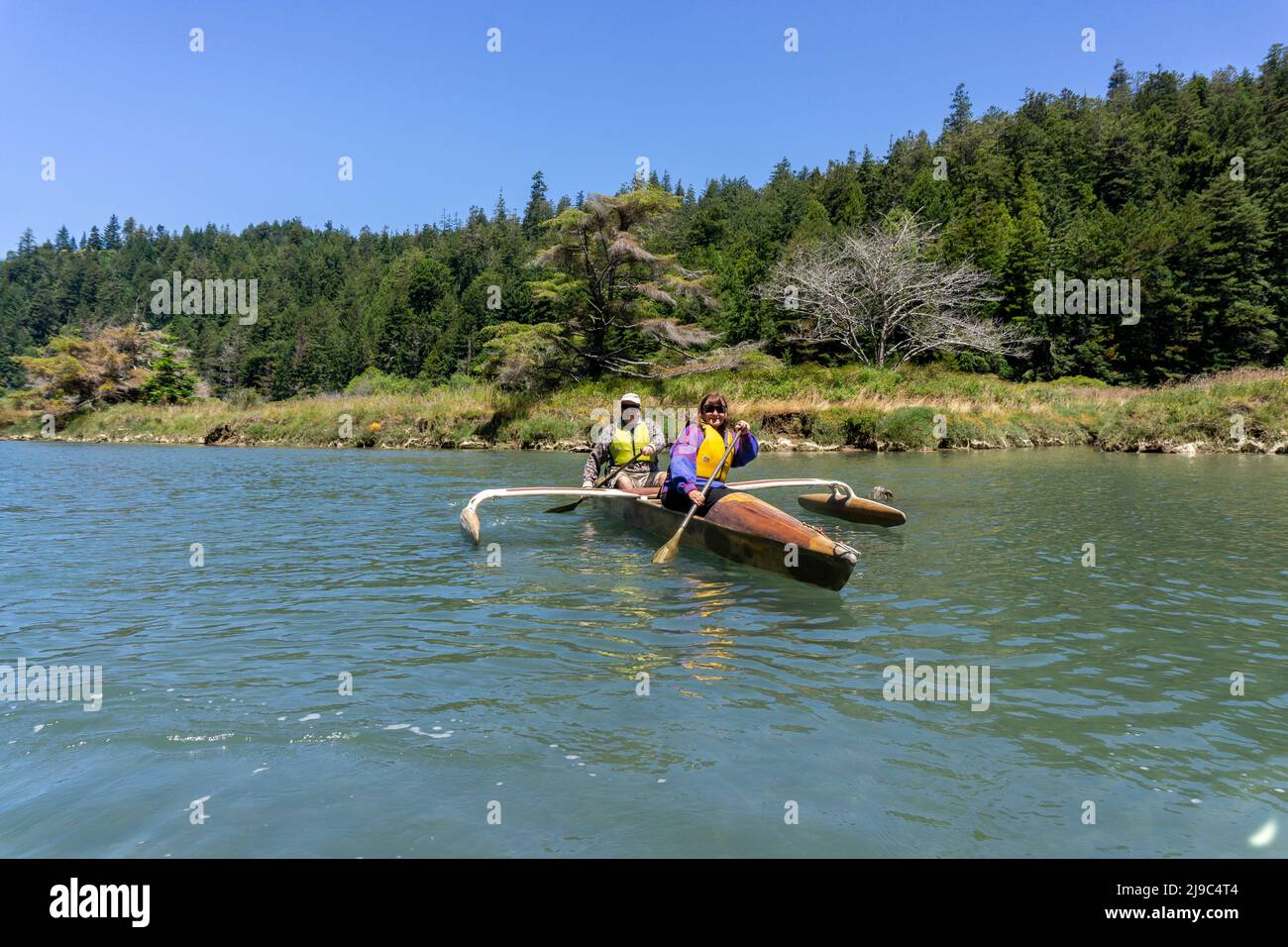 Couple on outrigger canoes on the Albion river in California. Stock Photo