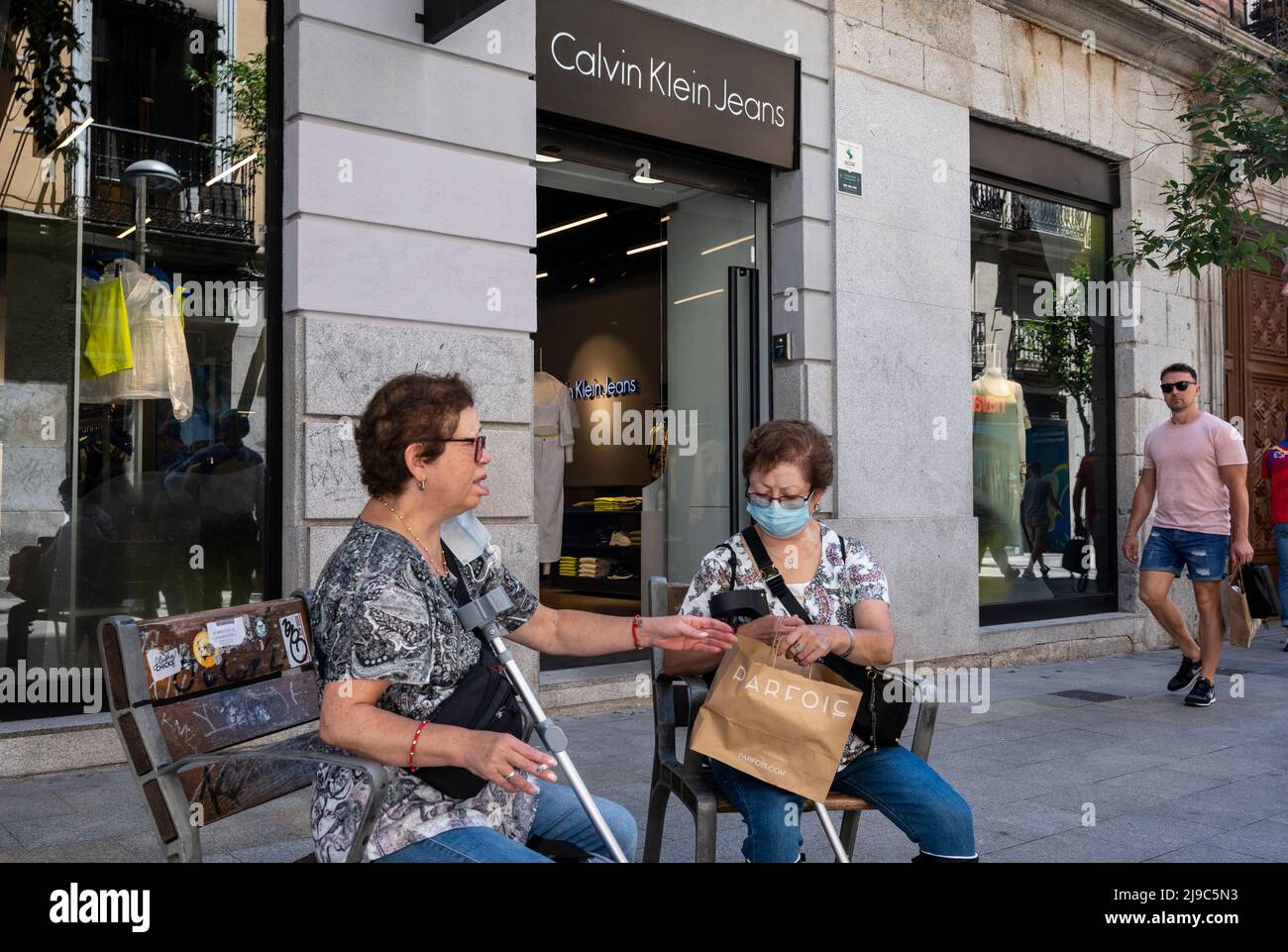 May 17, 2022, Madrid, Spain: A shopper is seen sitting on a public bench as  she holds a shopping bag from the Portuguese women's accessories brand  Parfois in front of the American