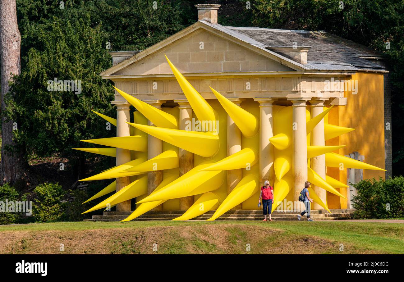 A giant yellow inflatable sculpture fills up one of the small temple-like buildings on the grounds of Fountain's Abbey near Ripon in England. Stock Photo