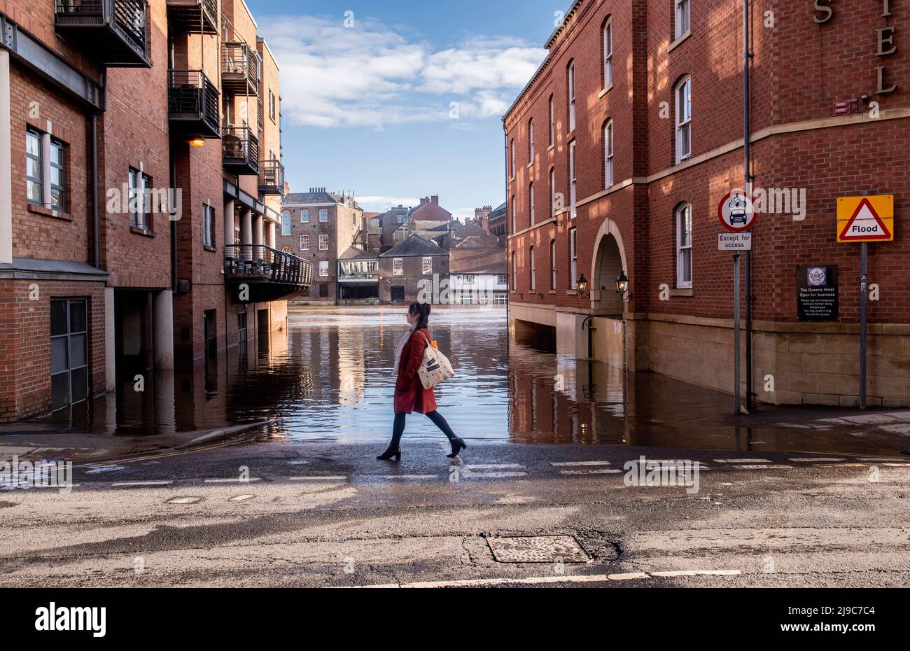 A woman passes a flooded area in the centre of York in England where the river Ouse burst its banks. Stock Photo
