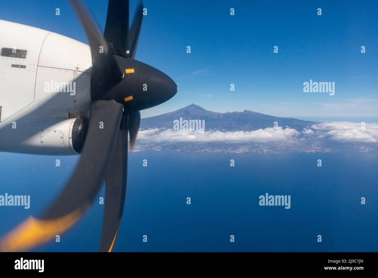 Flying propeller plane around Tenerife island with peak of Mount Teide