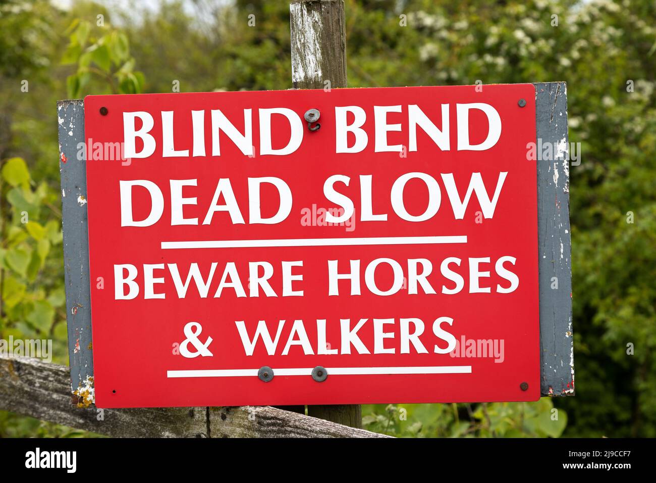 'Blind Bend, Dead Slow' reads a sign in Sunderland, England. It warns people to beware of horses and walkers. Stock Photo