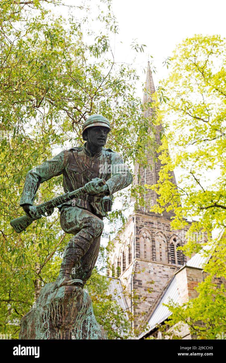 Soldier on the war memorial outside of St Cuthbert's Church in Darlington, County Durham, England. A statue of a soldier tops the memorial to the sold Stock Photo
