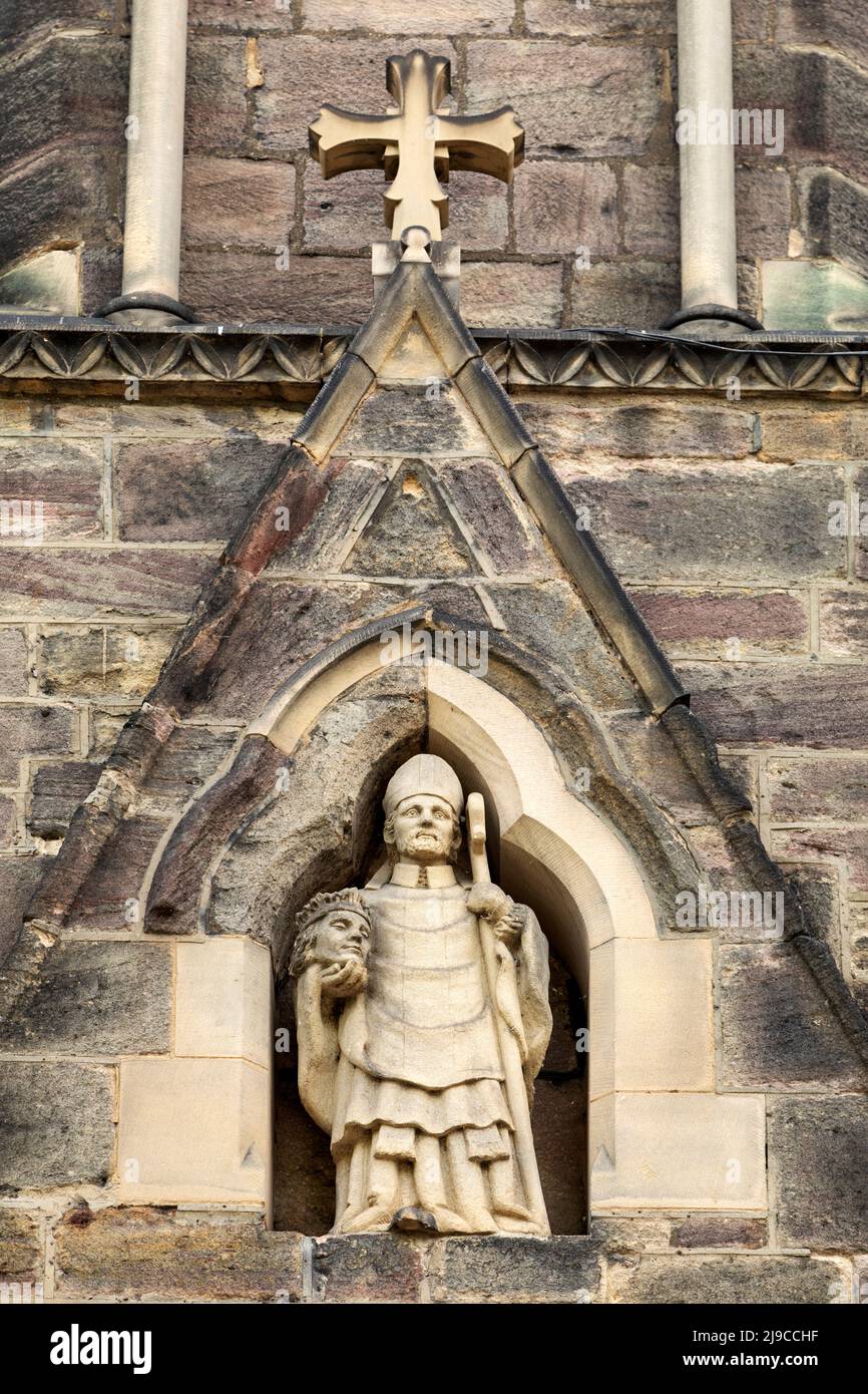 Depiction of St Cuthbert abiver the entrance to St Cuthbert's Church in Darlington, County Durham, England. Cuthbert of Lindisfarne lived during the 7 Stock Photo
