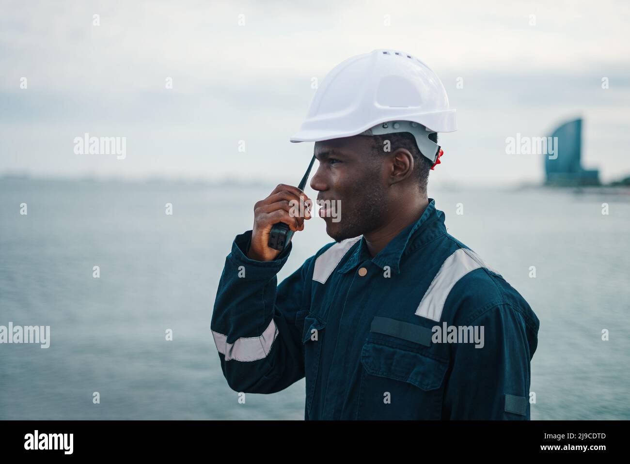 Black maritime worker speaking on walkie talkie Stock Photo
