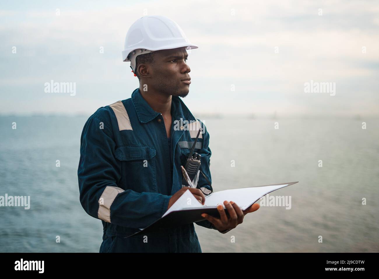 Pensive seaman filling papers in folder Stock Photo