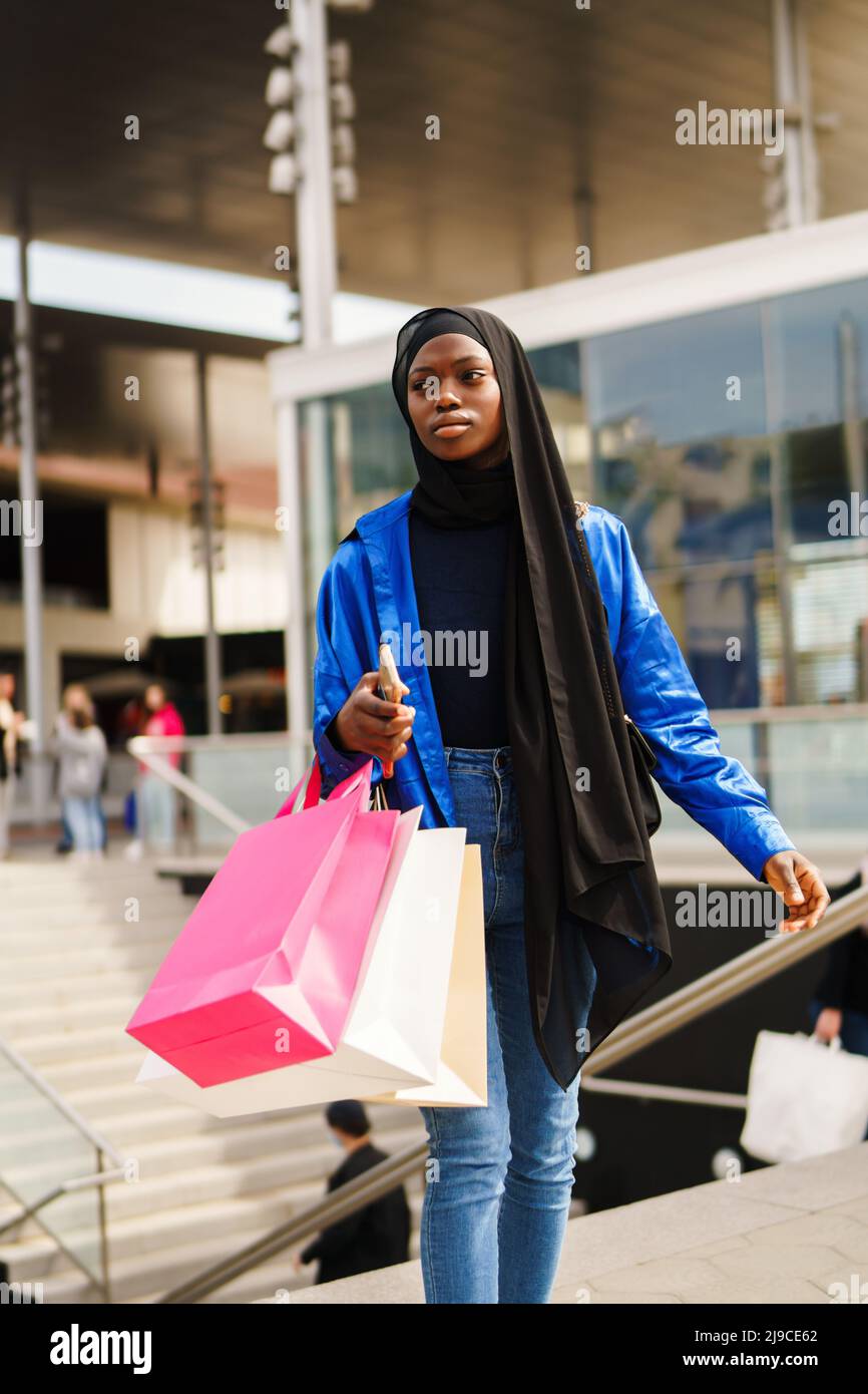 Black shopaholic walking inside mall Stock Photo