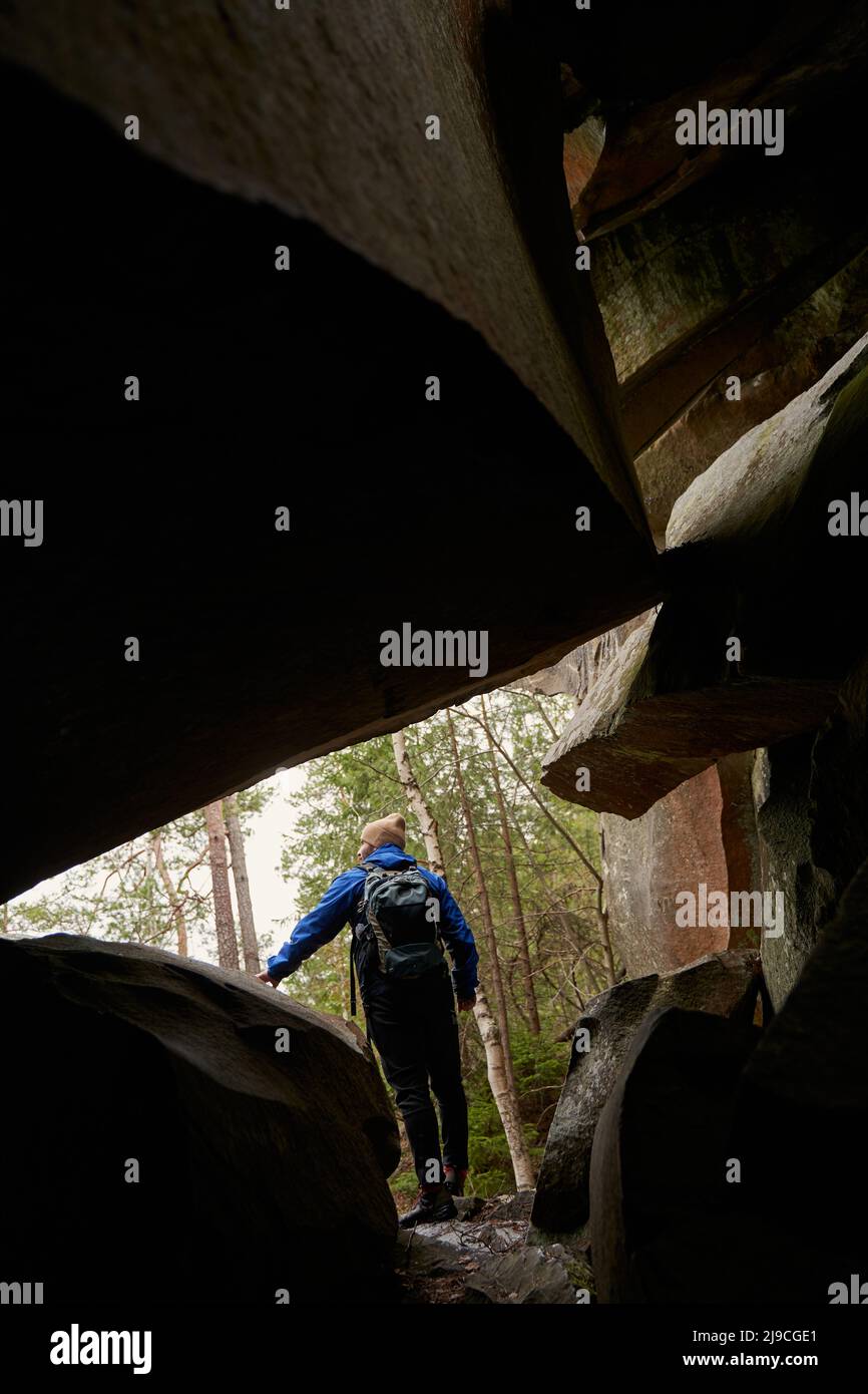 Silhouette of young adventurer standing near rock Stock Photo - Alamy
