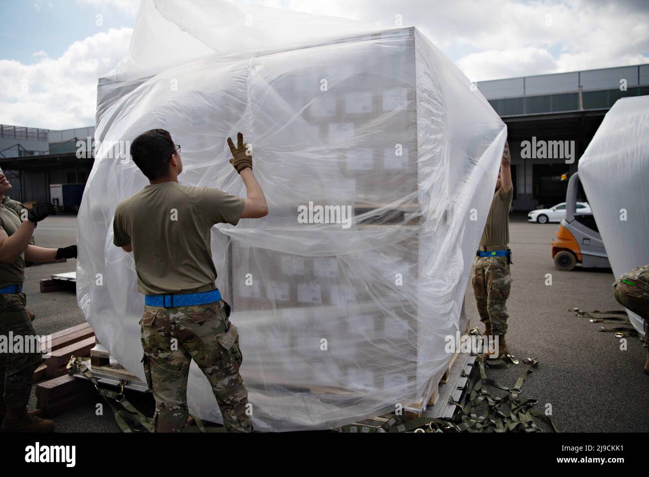 Ramstein-Miesenbach, Germany. 21st May, 2022. U.S. Air Force airmen assigned to the 721st Aerial Port Squadron place plastic over a pallet of infant formula, part of Operation Fly Formula at Ramstein Air Base, May 21, 2022 in Ramstein-Miesenbach, Germany. Operation Fly Formula, is coordinating shipments of formula from overseas factories to the United States to relieve the shortage caused by the closure of an Abbott factory. Credit: A2C Alexcia Givens/U.S Air Force/Alamy Live News Stock Photo