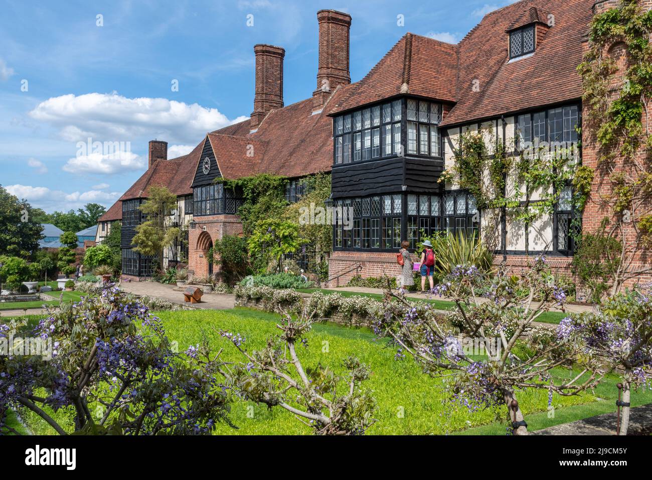 RHS Wisley Garden, the old Laboratory building with plants, including flowering wisteria, during May, Surrey, England, UK Stock Photo