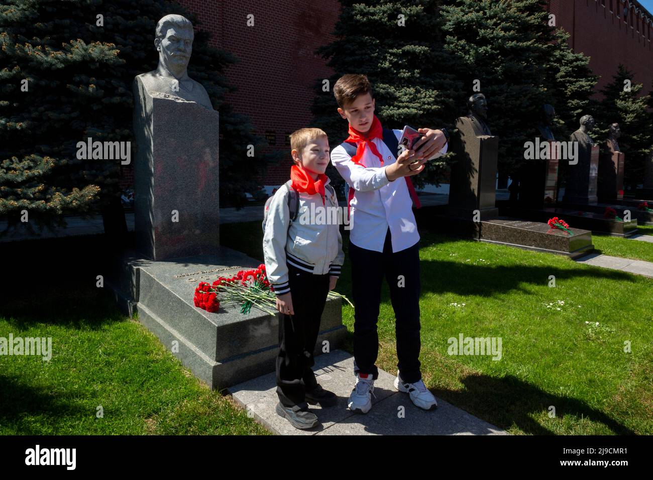 Moscow, Russia. 22nd May, 2022. Young pioneers take a selfie on a background of the tomb of Soviet leader Josef Stalin during a pioneer induction ceremony in Moscow's Red Square to celebrate joining the Pioneers organization and 100th anniversary of the All-Union Pioneer Organization, in Moscow, Russia. Nikolay Vinokurov/Alamy Live News Stock Photo