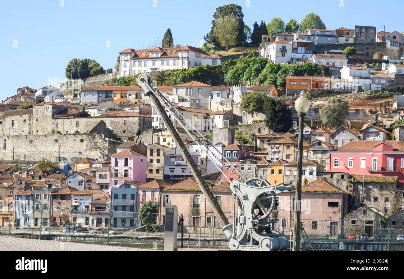 Old crane with the typical Porto houses in the background Stock Photo