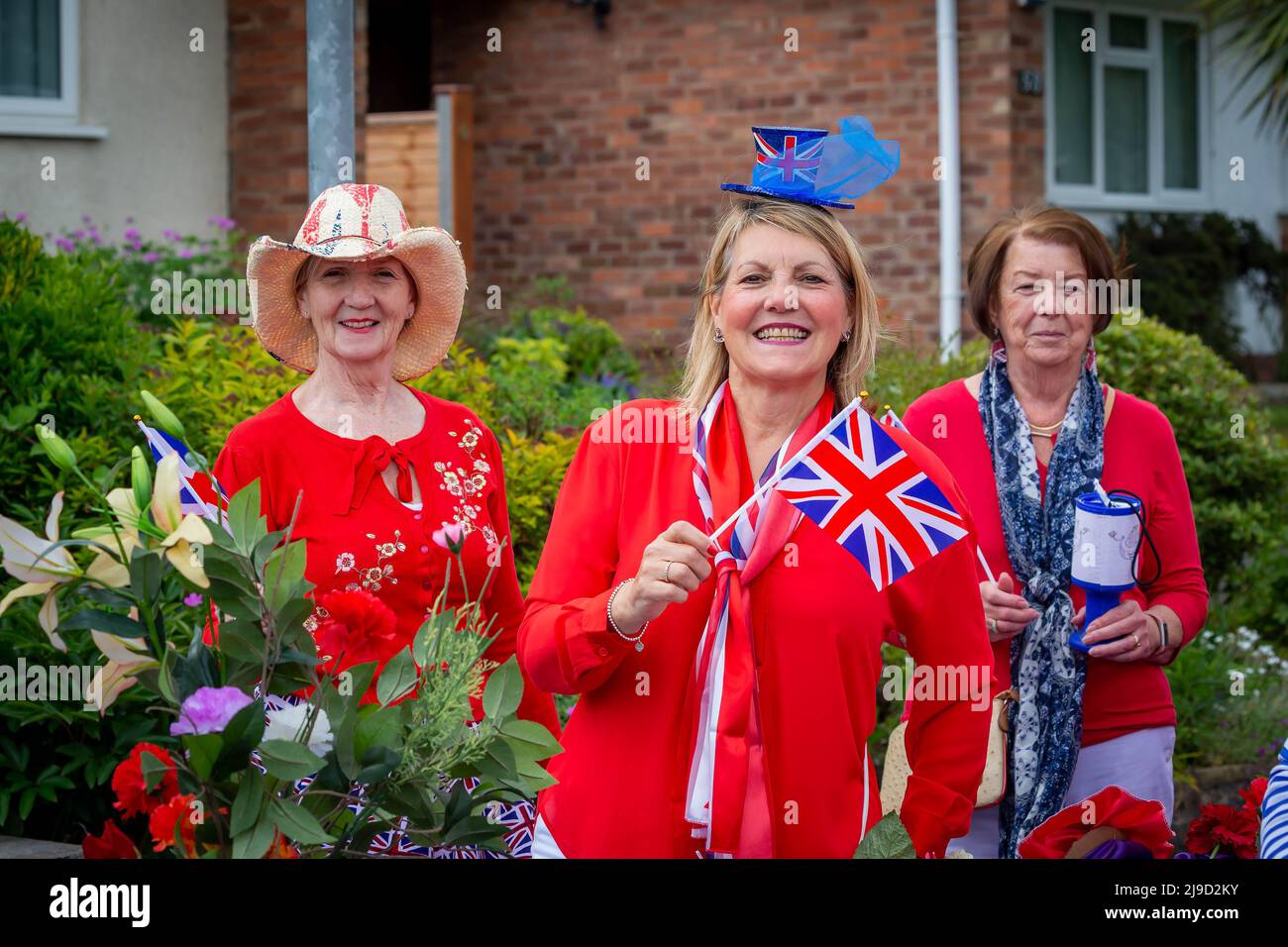 Ladies from the Lymm Women's Institute wave a flag at the 2022 Lymm May Queen Festival Stock Photo