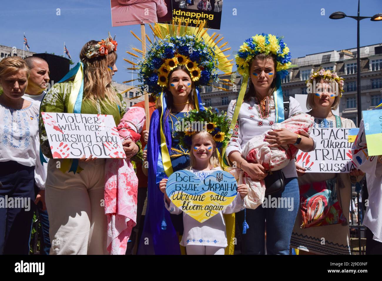 London, England, UK. 22nd May, 2022. Protesters wearing traditional flower headdresses, and two holding wrapped cloth resembling babies covered in blood, gather at Marble Arch. Crowds marched from Hyde Park to the Russian Embassy in London calling on the international community to help save the children in Ukraine and in protest against the atrocities reportedly committed by Russian forces. (Credit Image: © Vuk Valcic/ZUMA Press Wire) Stock Photo