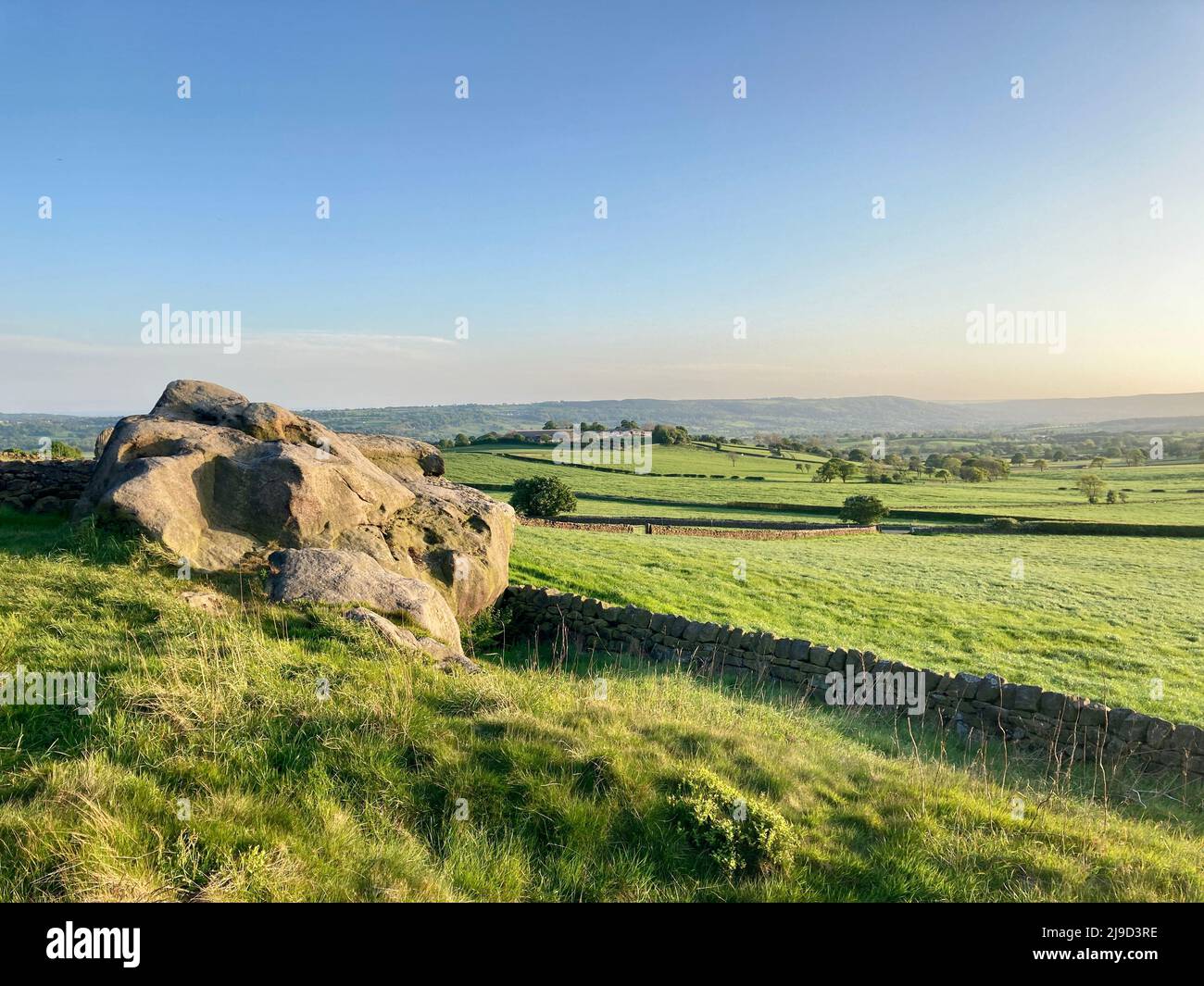 Scenic landscape view from Almscliff Crag towards the green agricultural farmers fields of the Yorkshire countryside in the Wharfe Valley. Stock Photo