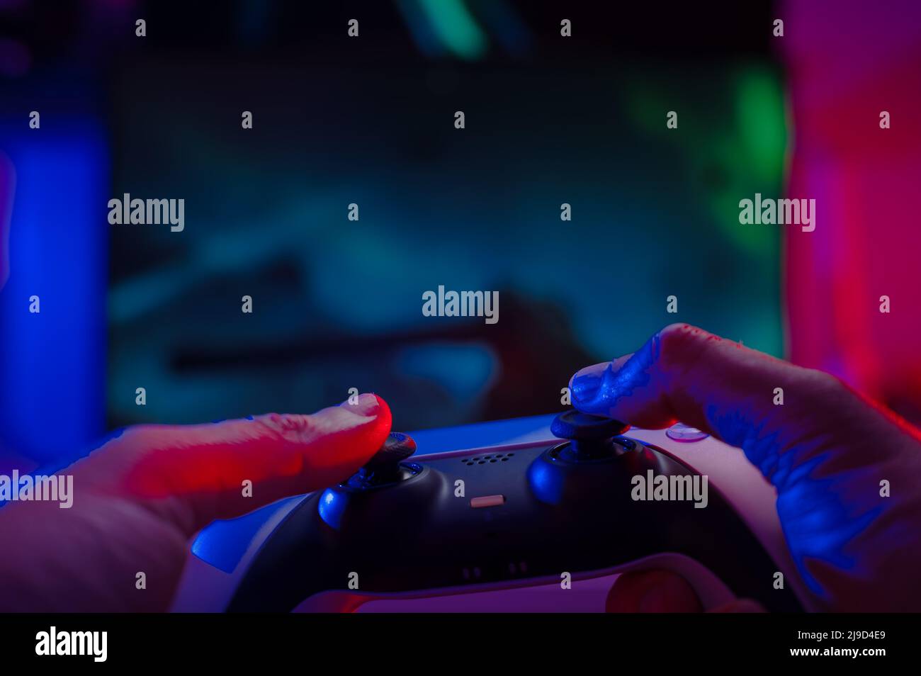 Close-up. The gamer holds a gamepad in his hands. Plays video games online  with friends. Neon lighting. Technological background. Game strategy, cyber  Stock Photo - Alamy