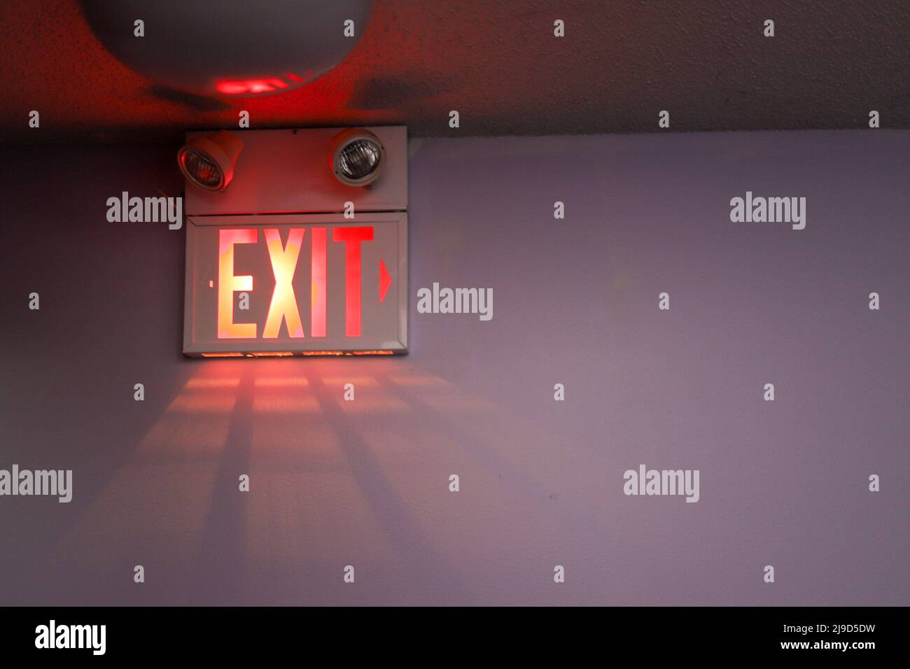 A exit sign on a white wall Stock Photo